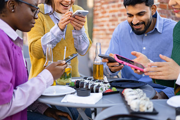 istock Friends Sharing Sushi and Phones 2225007926