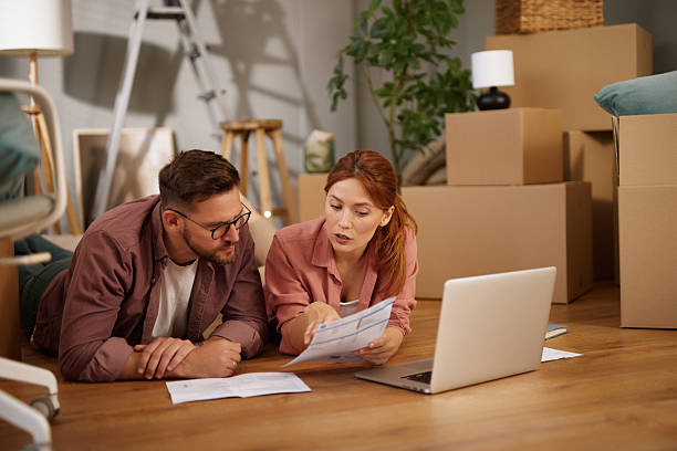 istock Young couple lying on floor checking documents in new home 2225008885