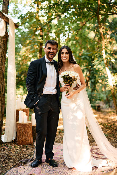 istock Happy Couple Smiling During Wedding Ceremony in Forest 2225009144