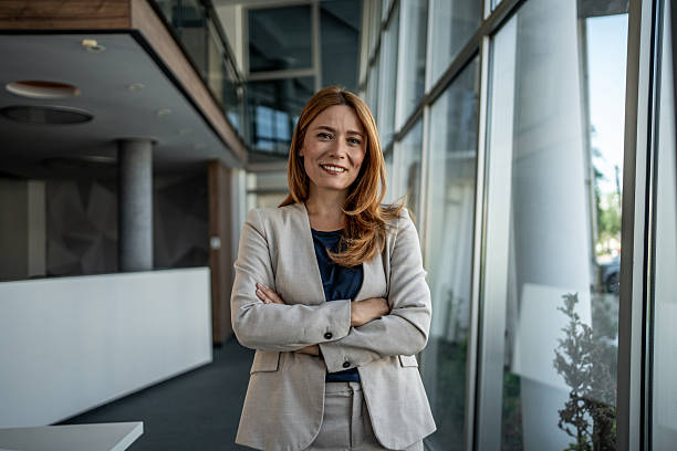istock Confident businesswoman smiling with folded arms in modern office 2225009152