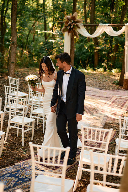istock Bride and groom leaving wedding ceremony in the forest 2225009302