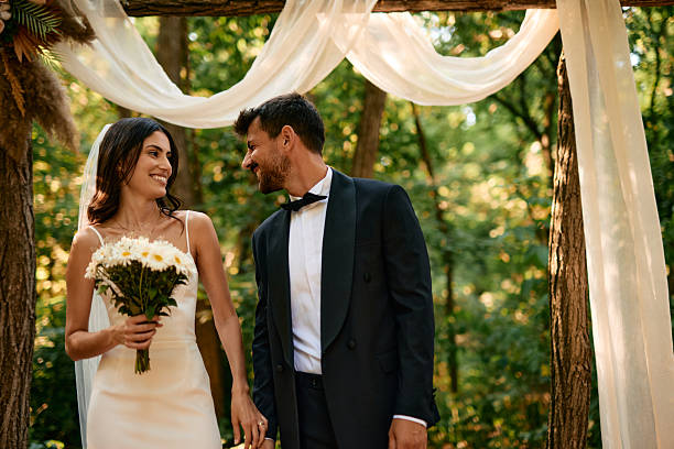 istock Bride and groom exchanging loving glances during their forest wedding ceremony 2225009495