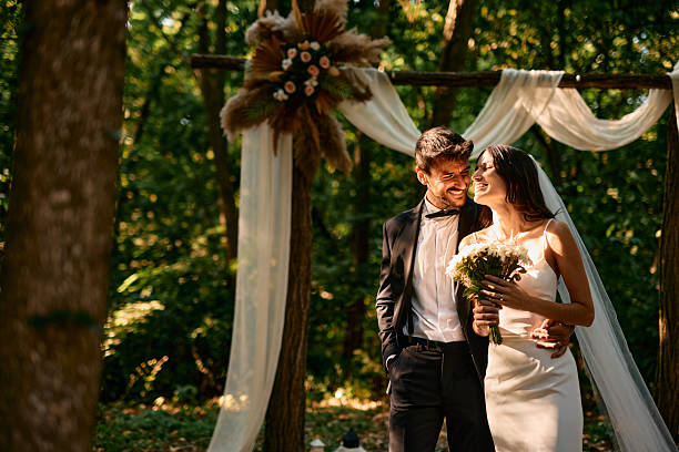 istock Happy Couple Smiling During Wedding Ceremony in a Forest 2225009560
