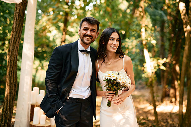 istock Happy Couple Smiling During Wedding Ceremony in Forest 2225009561