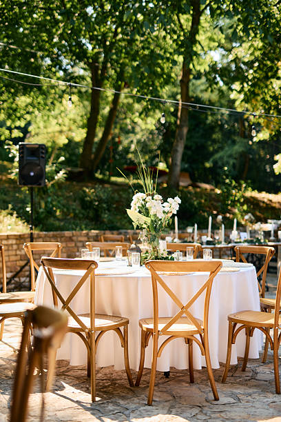istock Elegant round table with cross-back chairs and white tablecloth is awaiting guests in a beautiful garden 2225009821