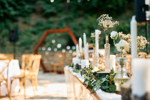 istock Wedding reception table decorated with greenery, candles and flowers in the forest 2225010028
