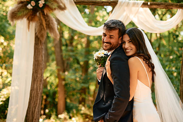 istock Bride hugging groom at outdoor wedding ceremony 2225010327