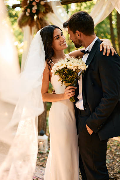 istock Bride and groom embracing at outdoor wedding ceremony 2225010362
