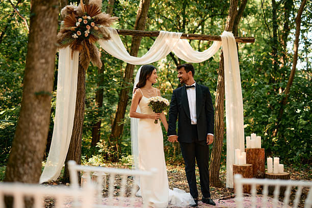 istock Bride and groom holding hands during their wedding ceremony in the forest 2225010612