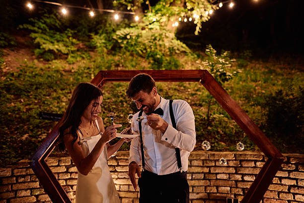 istock Happy newlyweds eating wedding cake at night 2225010661