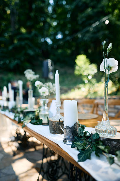 istock Decorating a wedding table with candles and flowers in the forest 2225010692