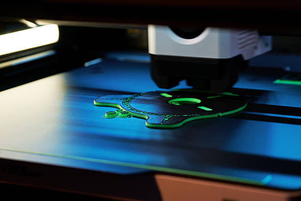 3D Printer in Action Creating a Detailed Object With Green Filament in a Modern Workspace stock photo