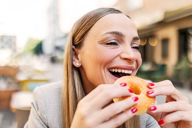 istock Young woman eating a donut 2225013302
