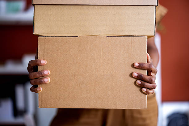 istock Person Carrying Large Cardboard Boxes in a Modern Indoor Setting 2225013855
