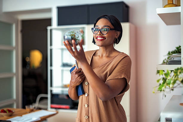 Young Professional Admiring a Glass Ornament in Modern Home Office Setting