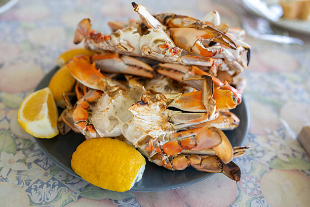 istock Freshly steamed blue crabs served with lemon wedges on a table 2225016531