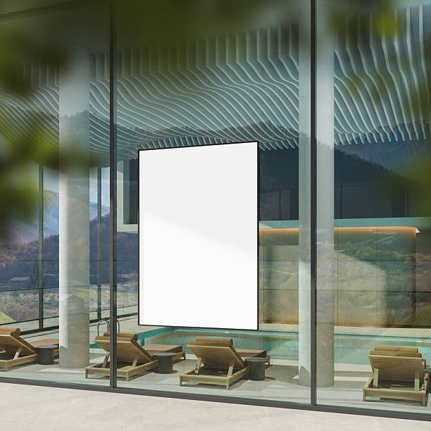istock Blank vertical poster mockup displayed on glass wall of modern spa lounge with poolside view and wooden recliners under daylight reflections. 3D Rendering 2225019713