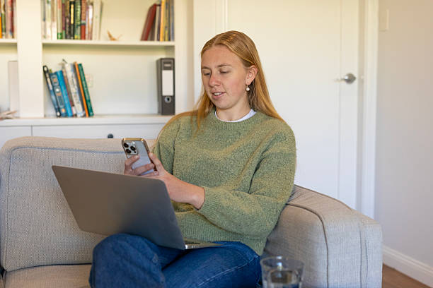 istock Young woman using a laptop computer on her couch 2225021711