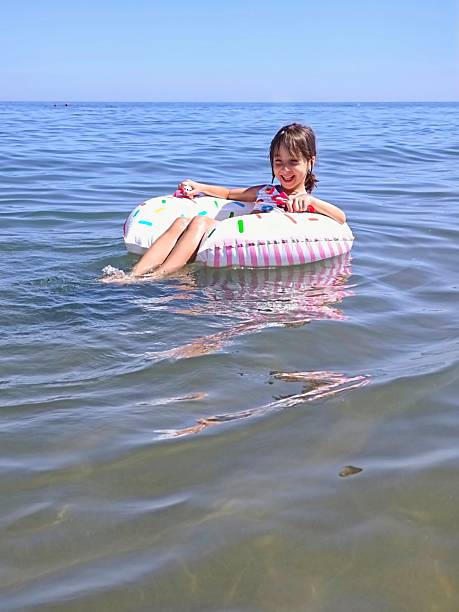 Little girl on inflatable donut shaped ring. High quality photo
