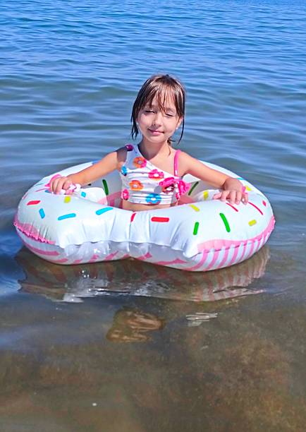 istock Little girl on inflatable donut shaped ring 2225025224