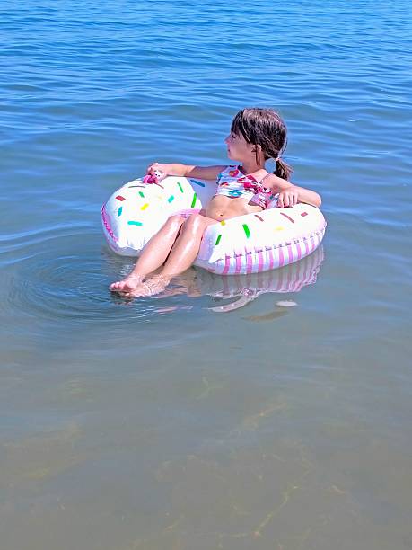 istock Little girl on inflatable donut shaped ring 2225025411
