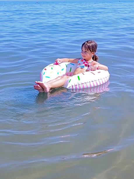 istock Little girl on inflatable donut shaped ring 2225026010
