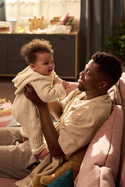 istock Young Black Father Smiling While Holding Infant Daughter during Paternity Leave 2225026148