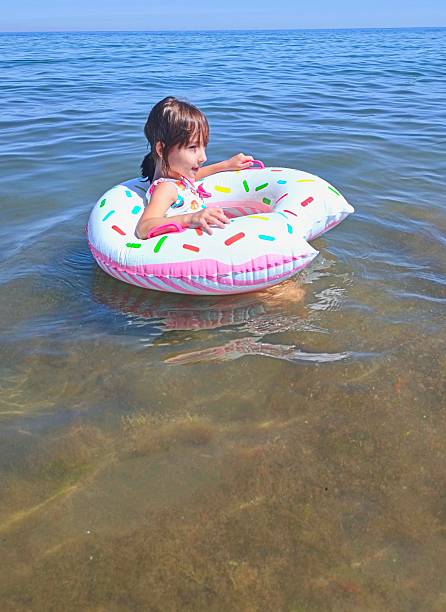 istock Little girl on inflatable donut shaped ring 2225026447