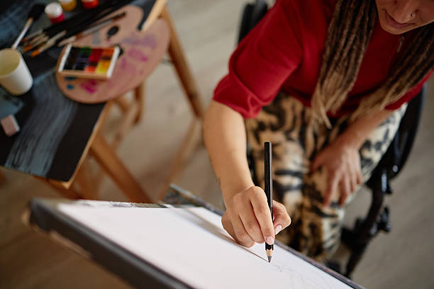 istock Woman with Disability Drawing on Canvas in Wheelchair 2225027708