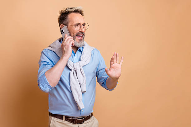 istock Mature businessman using a smartphone in a professional setting, making gestures and showing expressions 2225030651