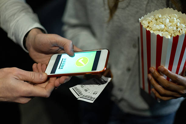 istock Usher scanning digital ticket on smartphone with popcorn bucket in background 2225031651