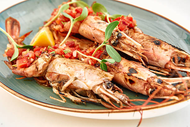 istock Grilled langoustines topped with tomato salsa and microgreens on ceramic plate 2225032014