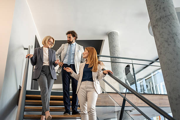 istock Businesspeople walking and talking on stairs in modern office 2225034332