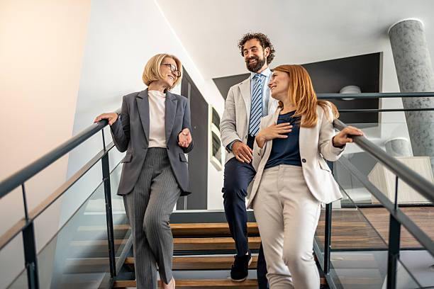 istock Businesspeople walking downstairs and talking in office 2225034334