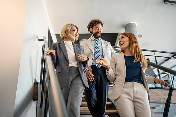 istock Businesspeople walking and talking on stairs in office 2225034338