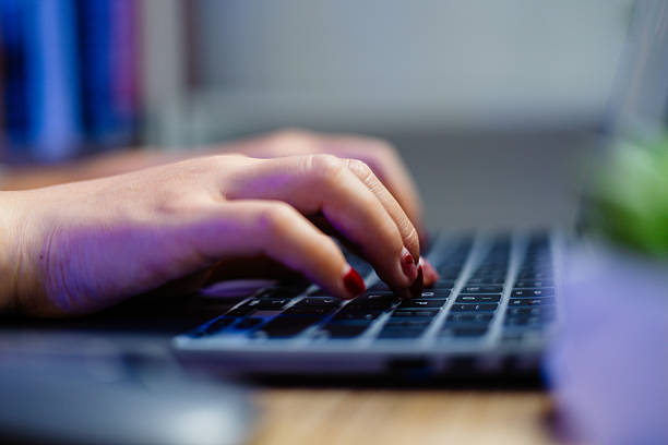 Selective focus shot, Asian woman hands typing on laptop in home office. Remote working. Freelance work.