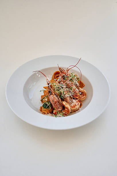 Elegant seafood tagliatelle with fresh herbs on white ceramic plate