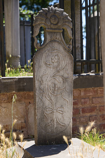 Shot of a carved angel sculpture atop a tombstone in old Gaspesie cemetery by the sea. Taken in Gaspesie, Quebec, Canada, during the day.