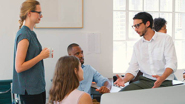 istock Multi-Cultural Business Team Having Informal Meeting Working At Desks In Modern Open Plan Office 2225037032