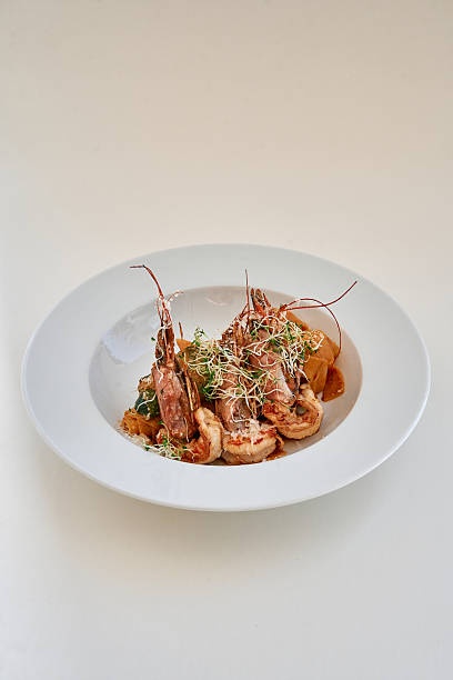 istock Delicious shrimp platter with fresh herbs and vegetables on white plate 2225040216