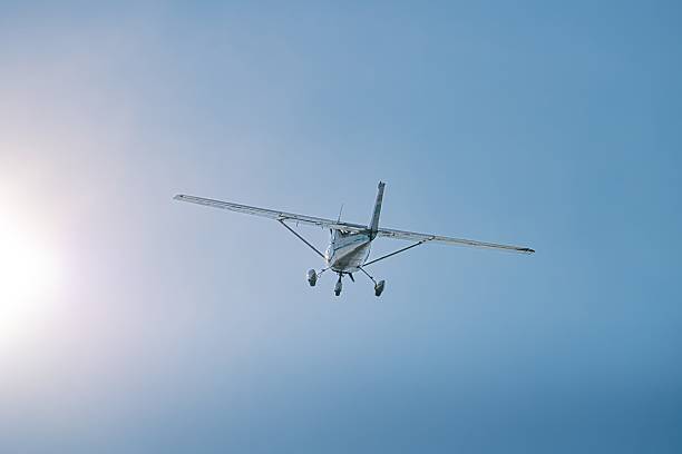 istock Small aircraft climbing into bright sky with sun flare 2225041107