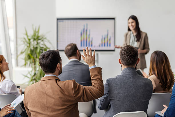 istock Rear view of businessman in conference room raising hand and asking questions about presentation. 2225041237