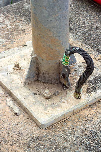 istock Grounding Connection: A Close-Up of Metallic Pole Securely Anchored with Braided Cable 2225042910