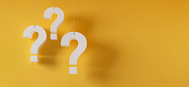 istock Three hanging white question marks in front of a yellow wall 2225043043