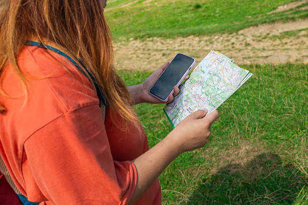 istock Young Female Hiker Navigating Trail with Map and Smartphone 2225045104