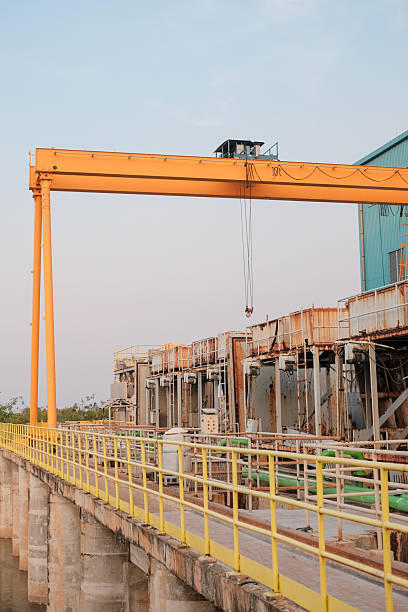 istock Industrial landscape featuring a gantry crane and processing plant infrastructure 2225045192