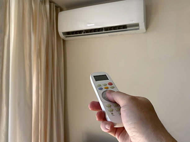 istock Close-up a man's hand turns on an air conditioner using a remote control in an apartment or house. 2225045424