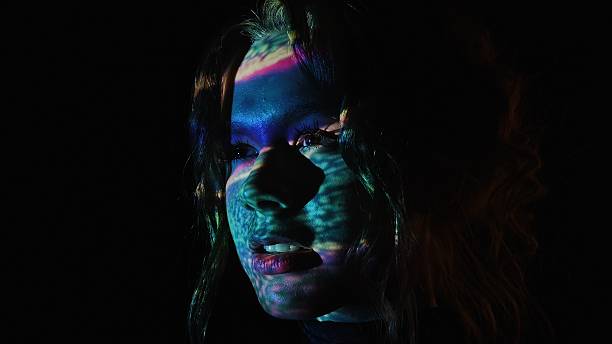 istock Colorful light reflections on a woman face in dark background 2225050822