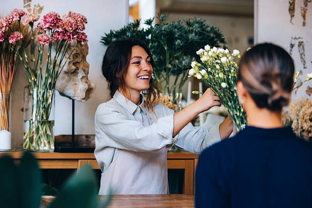 Florist Arranging Fresh Flowers for a Customer at a Decorative Shop