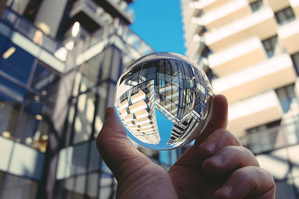 istock Hand holding crystal ball with skyscrapers in background 2225052808